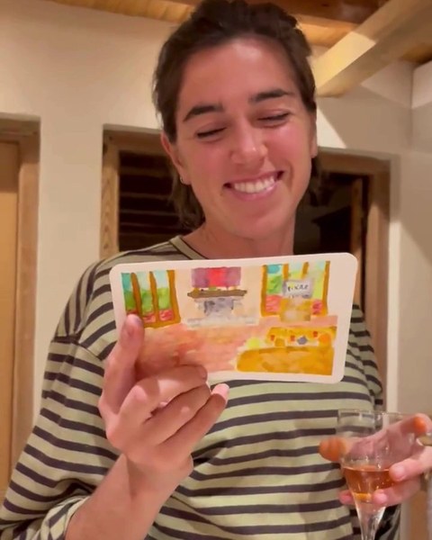 Se ríe mostrando su postal.