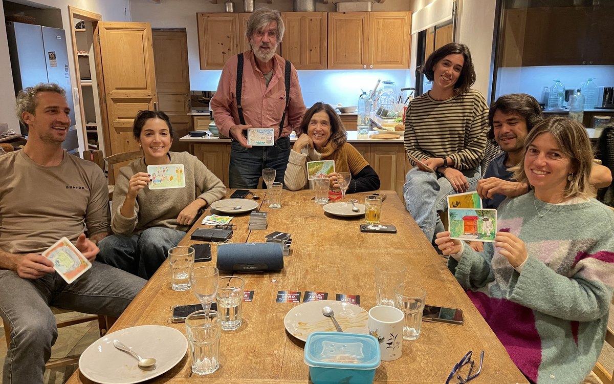 Una familia alrededor de la mesa, cada uno con su postal terminada.