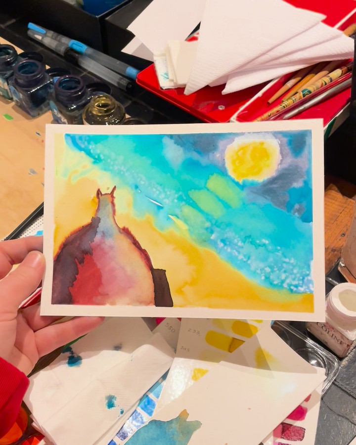 La postal de la luna, terminada, en la mano.